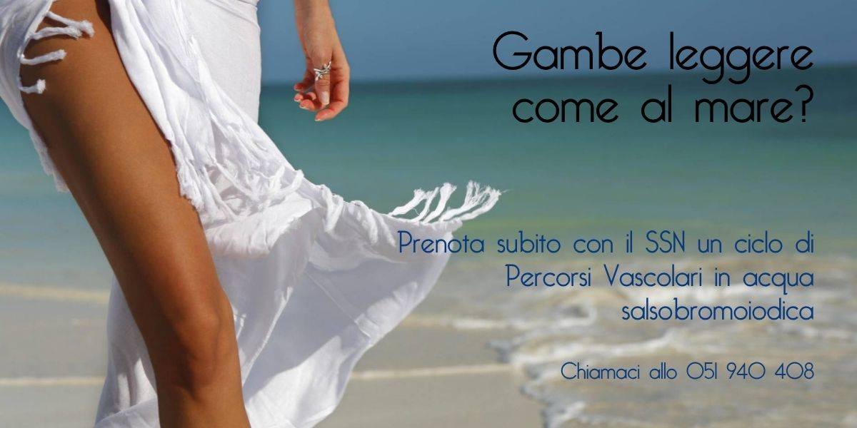 Gambe di donna in piedi con pareo bianco e il mare sullo sfondo