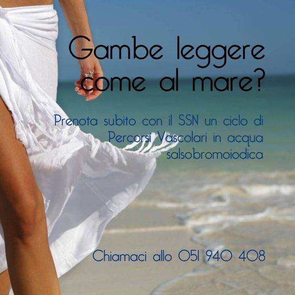 Gambe di donna in piedi con pareo bianco e il mare sullo sfondo
